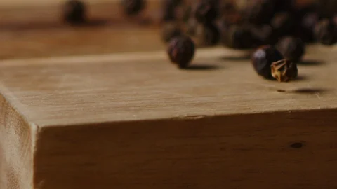 Scattering black pea pepper on kitchen table macro shot Stock-Footage 128493141