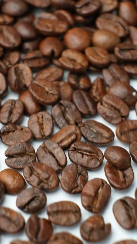 Scattering of decaf coffee beans on a white background, vertical slow motion mac Stock Footage 300996365