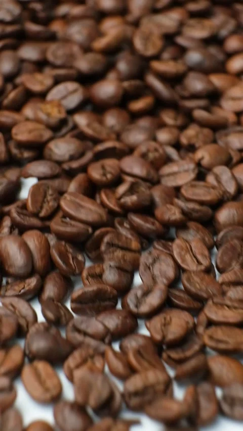Scattering of decaf coffee beans on a white background, vertical slow motion mac Stock Footage 302177504