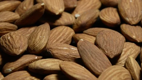A scattering of dried almonds on a dark background, a pile of nuts, camera movem Stock Footage 146337044