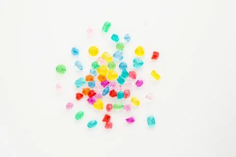 A scattering of many small different gems on a white background. Multicolor Stock Photos