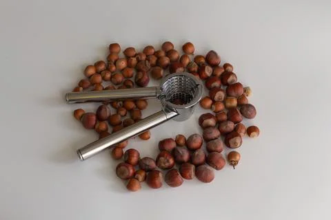 Scattering of nuts next to a nutcracker on a light background Foto stock