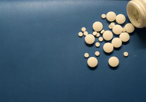 A scattering of pills on a blue table Stock Photos