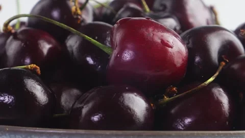 A scattering of ripe cherries with branches of shiny spinning in a circle. .. Stock Footage 303592356