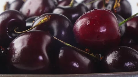 A scattering of ripe cherries with branches of shiny spinning in a circle. .. 库存影片 304083443