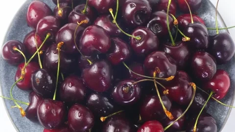 Scattering of ripe dark red cherries with branches rotating in a circle Stock-Footage 292820402