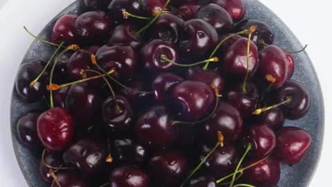 Scattering of ripe dark red cherries with branches rotating in a circle. Me.. Stock Footage 294704275