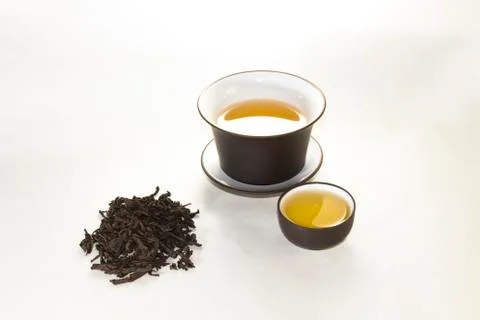 A scattering of tea and the Chinese cup on a white background Stock Photos