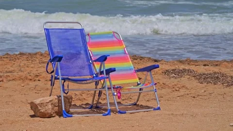 A scene of anticipated relaxation: empty beach loungers set against the slo.. Video stock 248436612