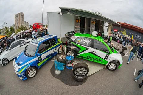 Scene at auto racing event featuring a blue-green race car number 8 and a sup Stock Photos