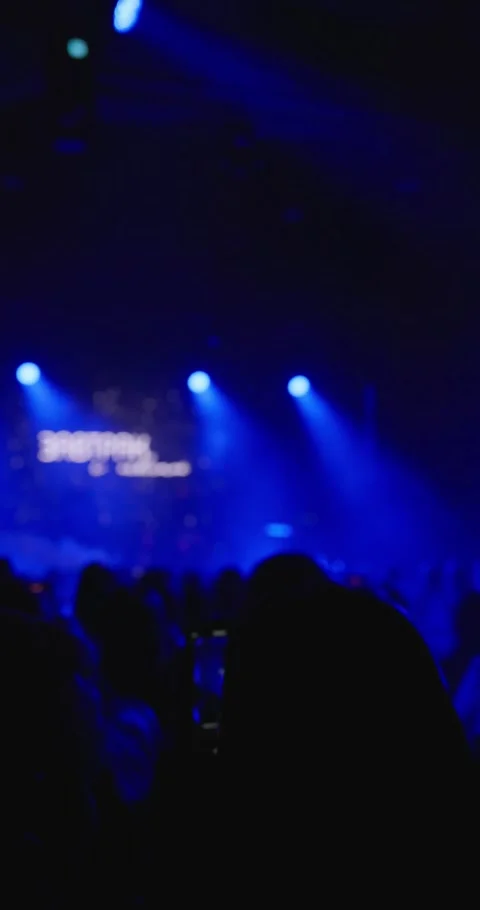 A scene with blue lights in the distance behind the heads of people Stock Footage 270222005