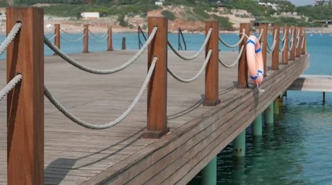 Scene of calm bathing place with emty wooden stage with ropes and lifebuoy and Stock Footage 56752191