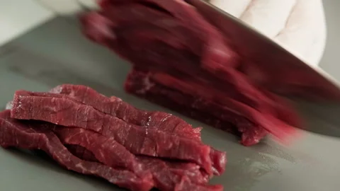 A scene of cutting fresh beef with a knife on a chopping board. The process of m Stock Footage 247231803