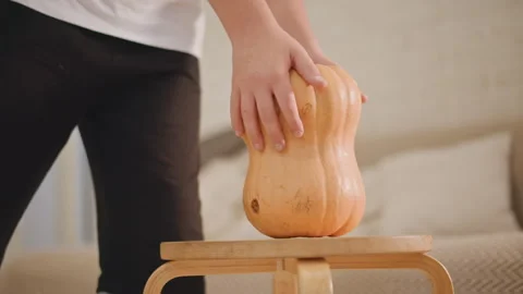 Scene depicting baker arranging pumpkin carefully. Baker setting pumpkin on Stock-Footage 346390348