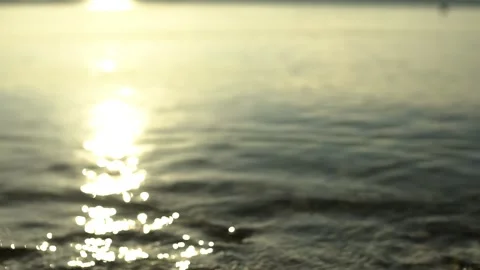 Scene of a lakeshore with pebbles in the lower foreground, reflection of the sun Stock Footage 248060959
