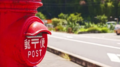 A scene with an old type of red postbox in a rural town Stock Footage 134223042