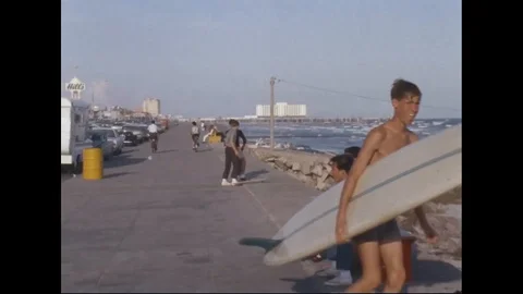 Scene of people on beach, boy with surf board and kids ride skateboard - 1965 Stock Footage 101920710