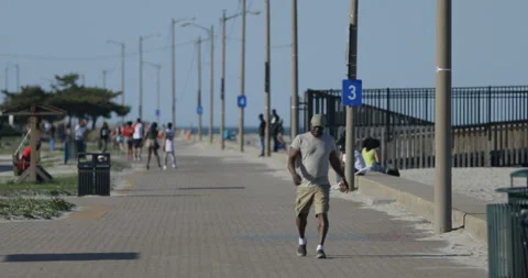 Scene of People Walking on a Path next to a Beach Stock Footage 142593888