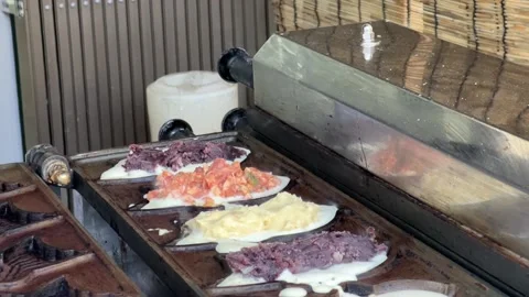 The scene of putting red beans in bread to make fish-shaped bun Видео 176619754