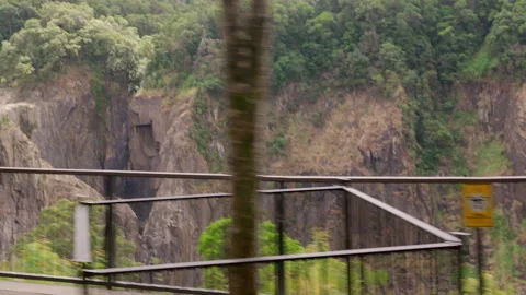 Scene of rugged gorge comes into view from moving train leaving station Stock Footage 323576343