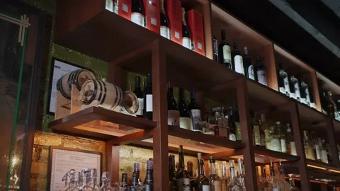 Scene Showcasing Diverse Spirits On Backlit Wooden Shelves With Vibrant Lighting Stock Footage 323897641