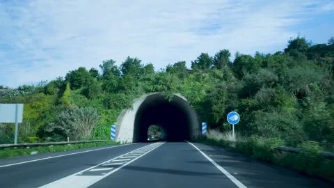 Scene Showcasing Roadway Heading Into Shadowy Tunnel With Lush Surroundings And Video stock 328049373