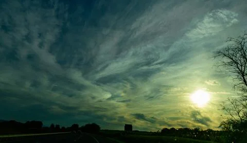 This scene shows a dramatic sunset or sunrise with the sun low on the horiz.. Stock Photos