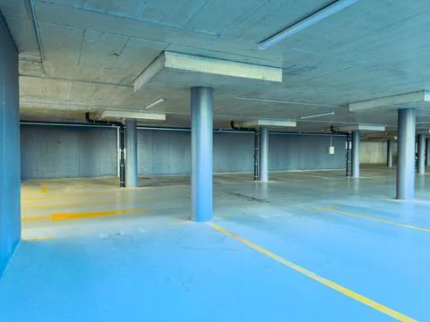 The scene shows a large empty parking garage. The floor is painted blue, and  Stock Photos