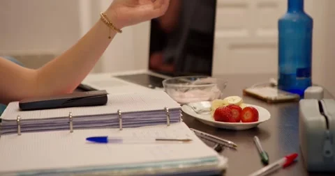 The scene shows a person's hand on a study desk Stock Footage 334776447