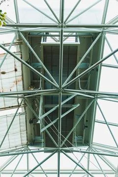 The scene shows the underside of a metal frame with beams and ceiling panels. Foto stock
