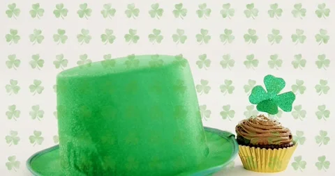 Scene starting with shamrock backdrop, green hat rising, cupcake emerging, Stock Footage 329471179