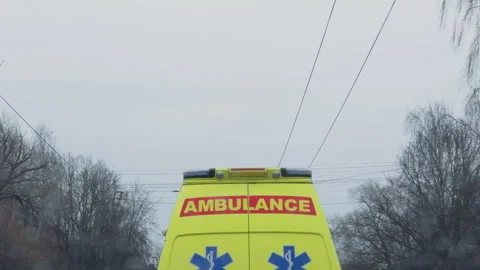 Scene of urgent medical response featuring ambulance under wires on wet asphalt Stock Footage 332356010