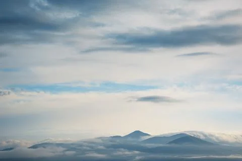 Scenery of clouds around mountain range Stock Photos