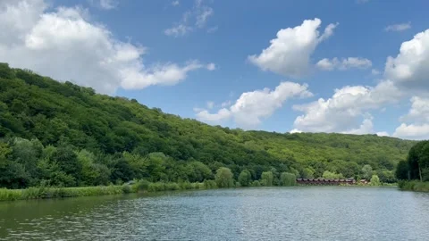 Scenery of mountain lake and hills with green forest and wooden houses Stock Footage 251661663