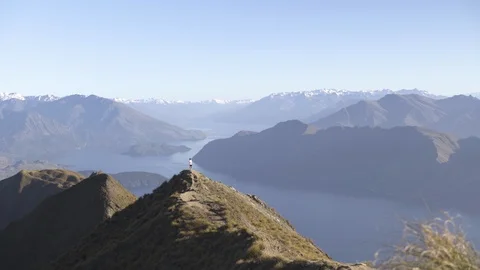 Scenes of mountain ranges and man walking on the mountain trail Stock Footage 95011418