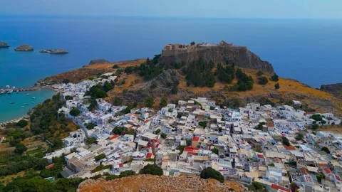 Scenic aerial drone view of the ancient acropolis, white town, and blue sea Stock Footage 341460735