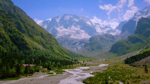 Scenic aerial flight over a river valley towards snowy mountains Stock Footage 337010323