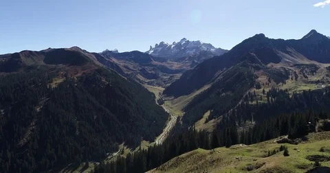 Scenic aerial scene. River between two mountains and snowy summit peak behind Stock Footage 80919325