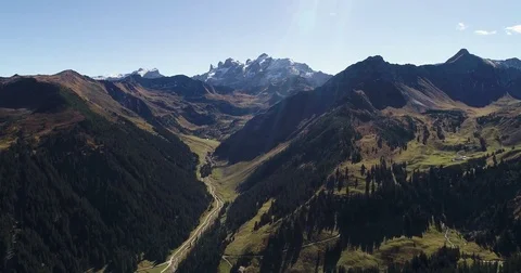 Scenic aerial scene. River between two mountains and snowy summit peak behind Video stock 80919414