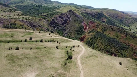 Scenic aerial view of dramatic volcanic rock canyon and unpaved country trails  Stock Footage 337676513