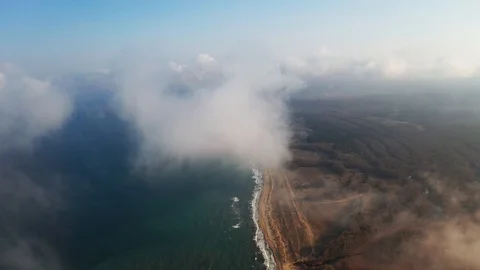 Scenic aerial view through moving white clouds on coastline and sea surface Stock Footage 106375498
