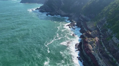 Scenic aerial view of waves crashing against rocky cliffs Видео 341908726