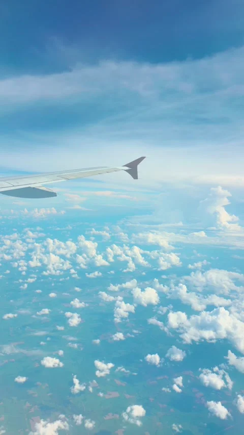 Scenic airplane wing view over blue sky and fluffy white clouds during flight Vídeo Stock 333840611