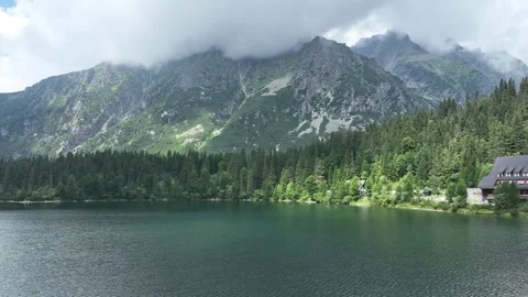 Scenic alpine lake surrounded by forest and mountain peaks Stock Footage 345168422