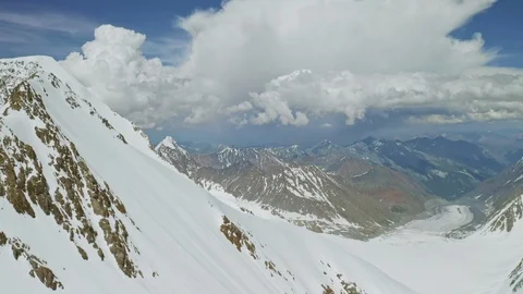Scenic alpine panorama, overcast cloud float above snowy misty mountain ranges Stock Footage 126372363