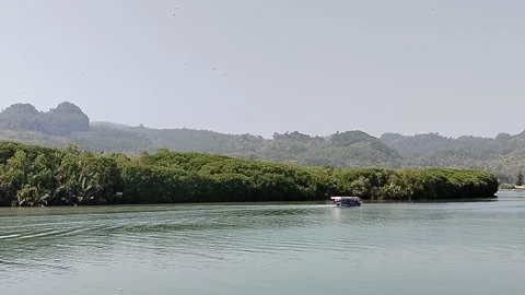 A scenic boat navigating the estuary where the river meets the sea, showcasing Vídeos de archivo 338375664