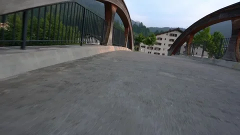 Scenic bridge pathway over rapid river in mountain town Stock-Footage 312677504