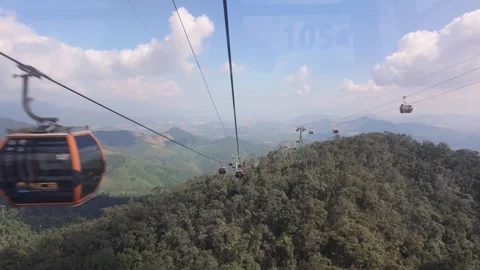 A scenic cable car glides above the lush mountains of Ba Na Hills Stock Footage 339266850