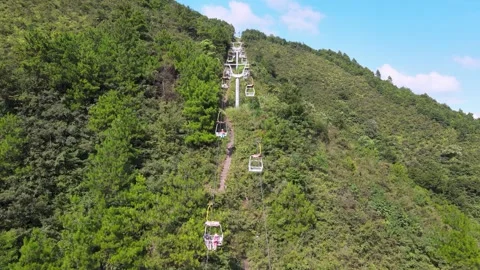 Scenic cable car ride ascending lush green mountain slope in Guilin China Stock Footage 342303287