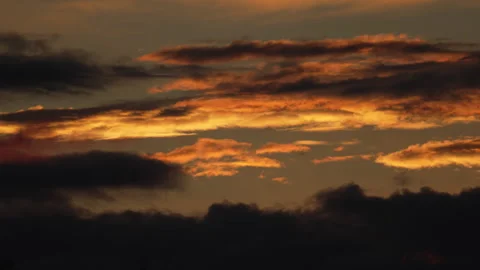 Scenic close up video on dark clouds moving over highlighted by golden Suns.. Stock Footage 253987226